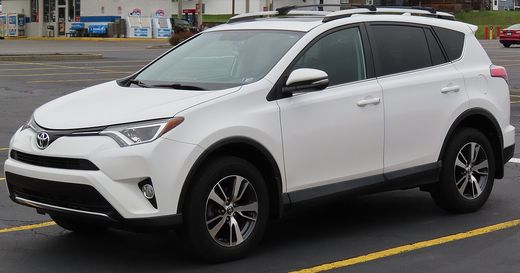 A white 2016 Toyota RAV4 XLE parked in a lot, seen from the front left