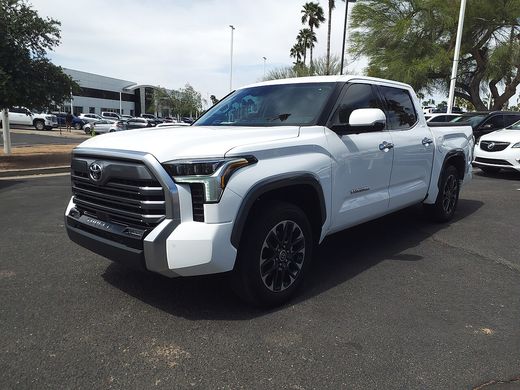 A white 2023 Toyota Tundra Limited CrewMax parked on a dealer lot, seen from the front left